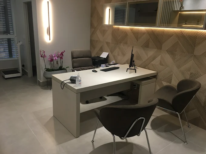 Detalhe acolhedor do consultório com iluminação suave e orquídeas